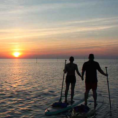 a happy couple paddleboarding at weight loss camp