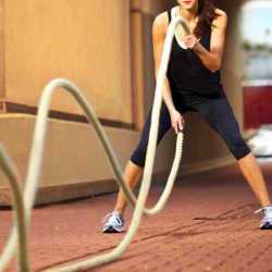 A young woman using the battle ropes outdoors at Weight Crafters in sunny Madeira Beach.